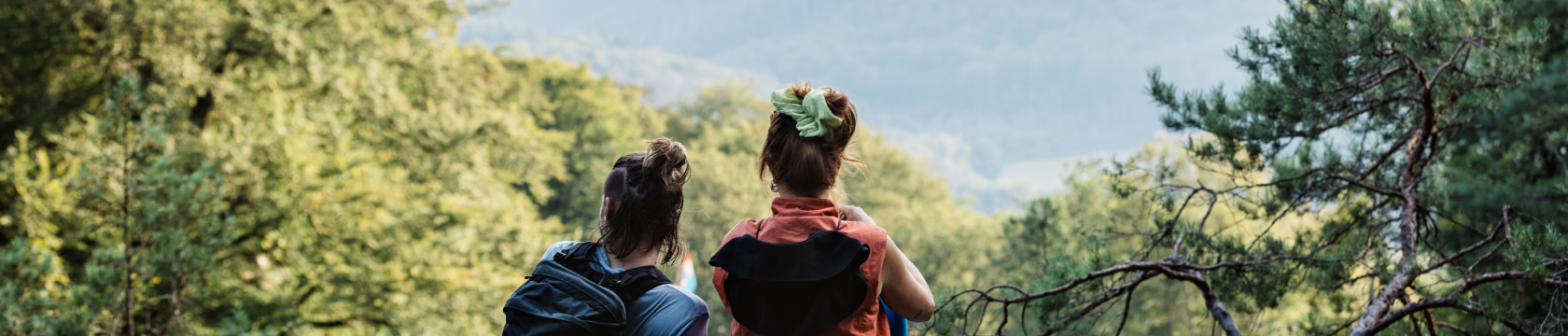 twee vrouwen kijken uit over een groen dal