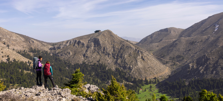 twee vrouwen met rugzakken lopen door de bergen