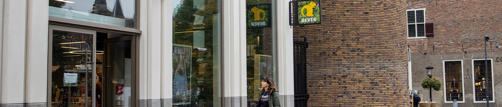 vrouw loopt een Bever-winkel binnen