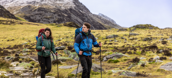 een man en vrouw wandelen door het bos