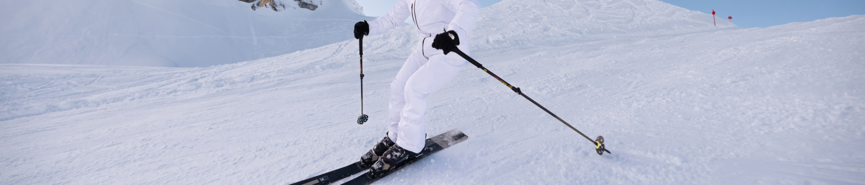 vrouw in witte skikleding op ski's